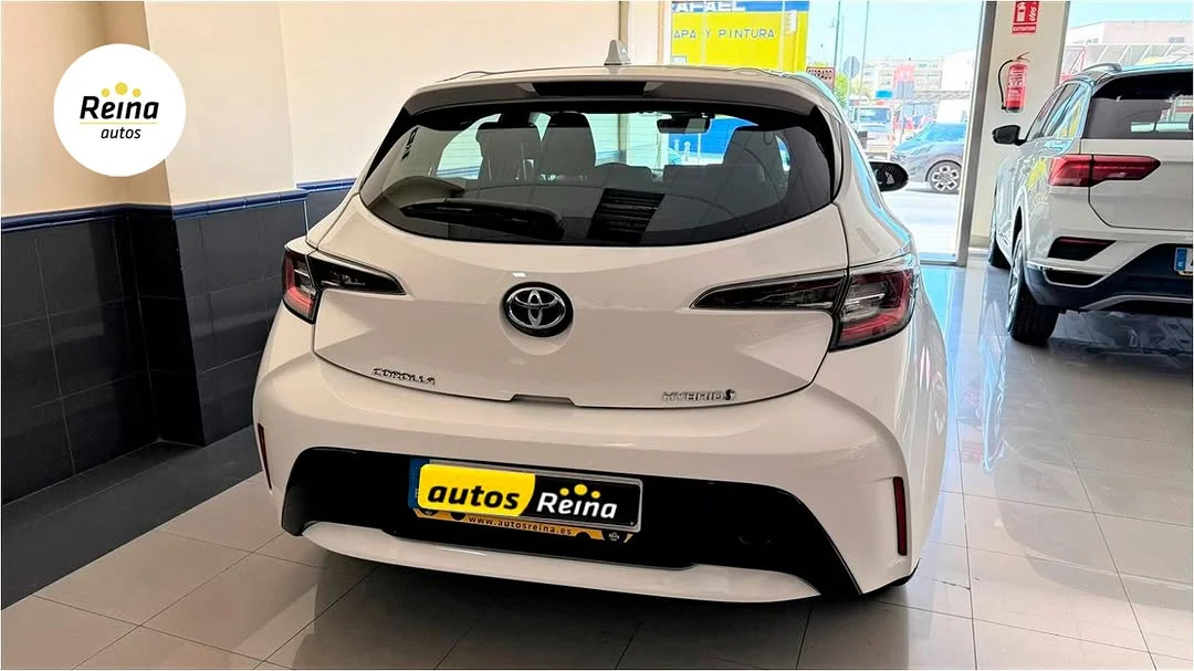 Vista trasera del Toyota Corolla híbrido con badge HYBRID y matrícula del concesionario Autos Reina en Mijas